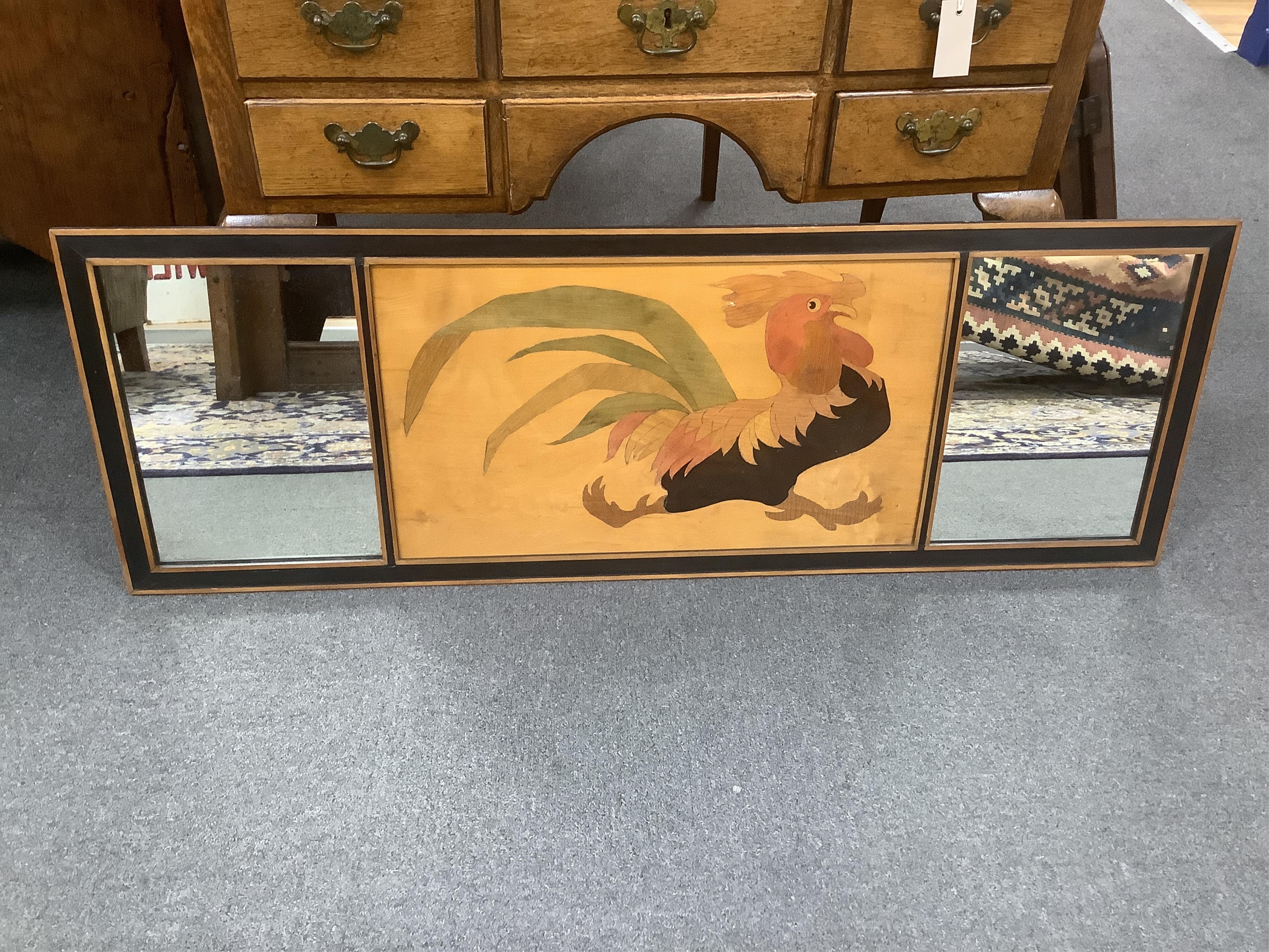 A three panel Rowley mirror, with an inlaid cockerel design to centre panel, width 121cm, height 42cm. Condition - good